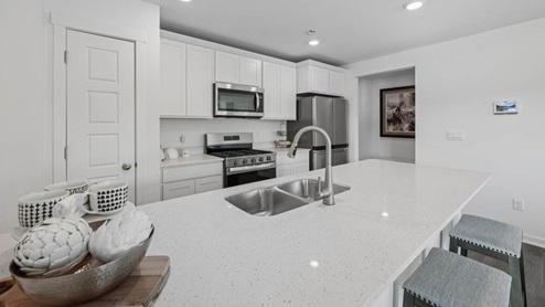 Kitchen with white cabinets and white quartz countertops