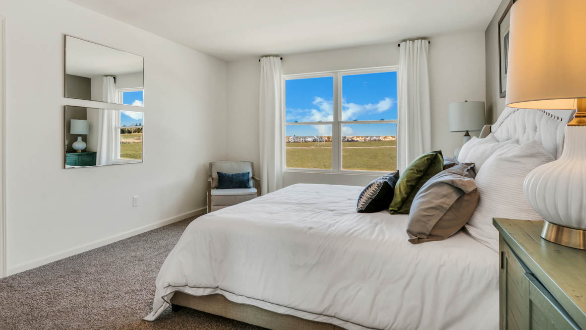 primary bedroom with carpet and large window view