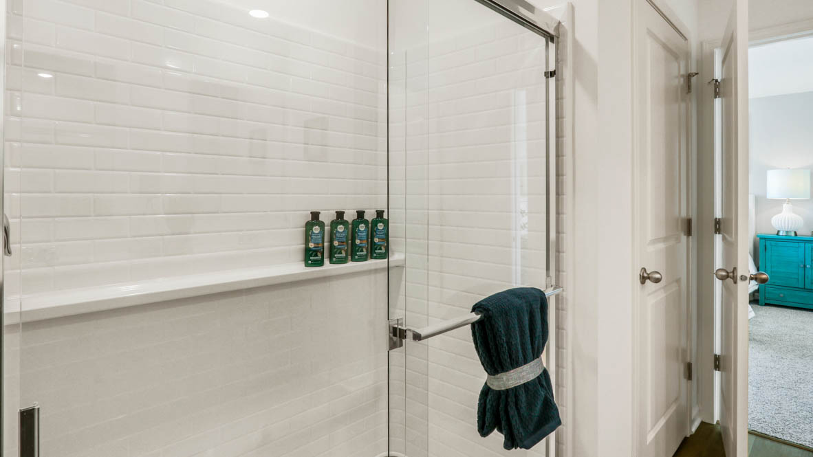 primary bathroom with walk in shower and linen closet