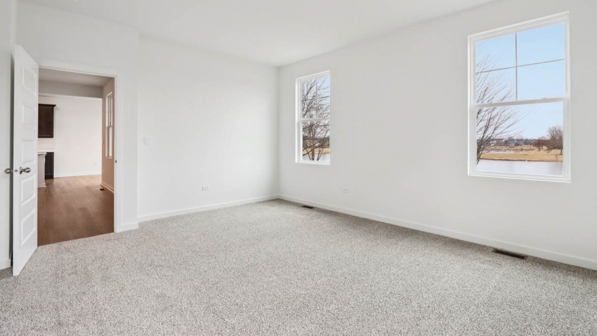 primary bedroom with carpet and large window view