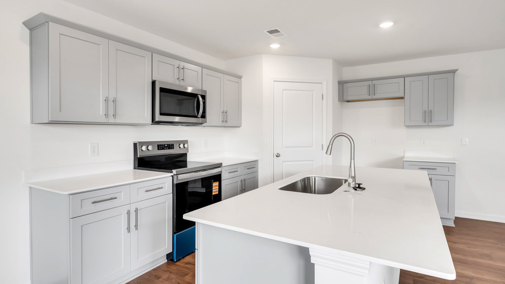 Kitchen with quartz counterops, stainless steel appliances, and shaker style cabinets