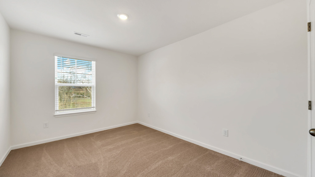 Bedroom with ample natural light and plush carpet floors