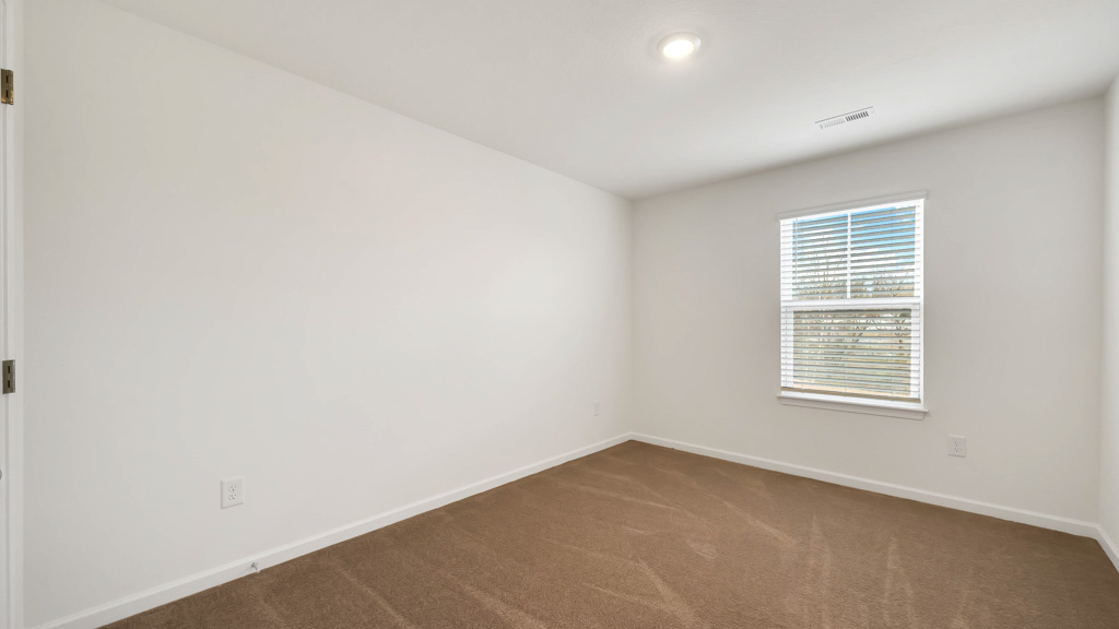 Bedroom with ample natural light and plush carpet floors