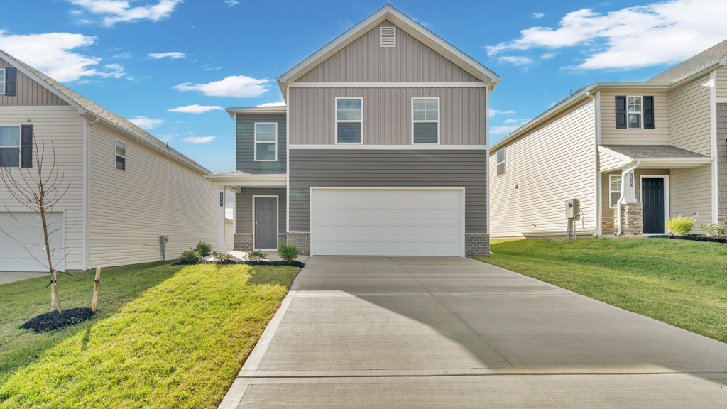 Front exterior of two story home with vinyl, board and batten, and brick