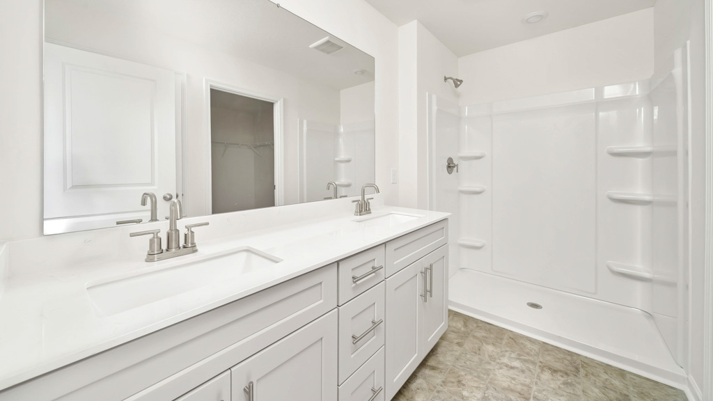 primary bathroom with double vanity and walk-in shower