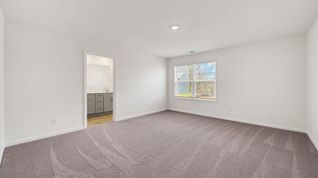 Primary bedroom with plush carpet floors and double light allowing windows