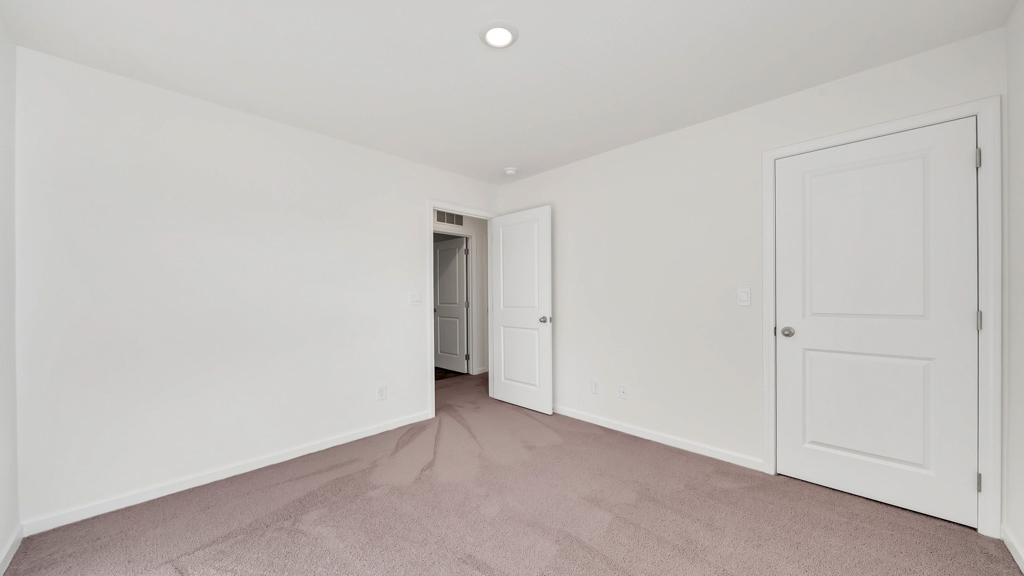 Bedroom with ample natural light and plush carpet floors