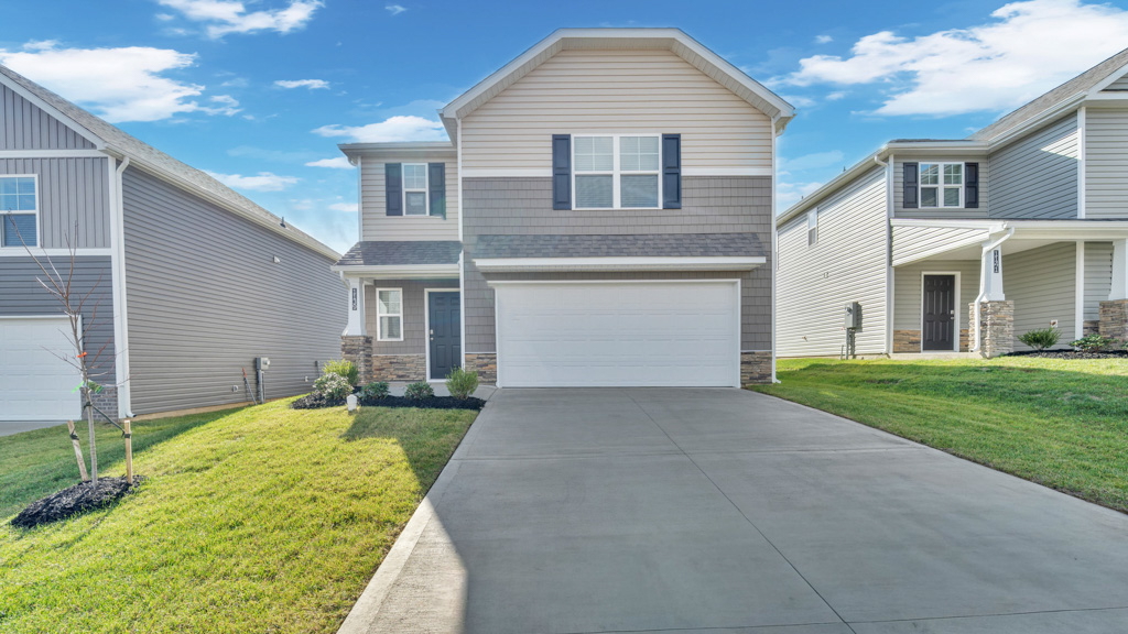 Front exterior of two story home with vinyl, shake, and stone