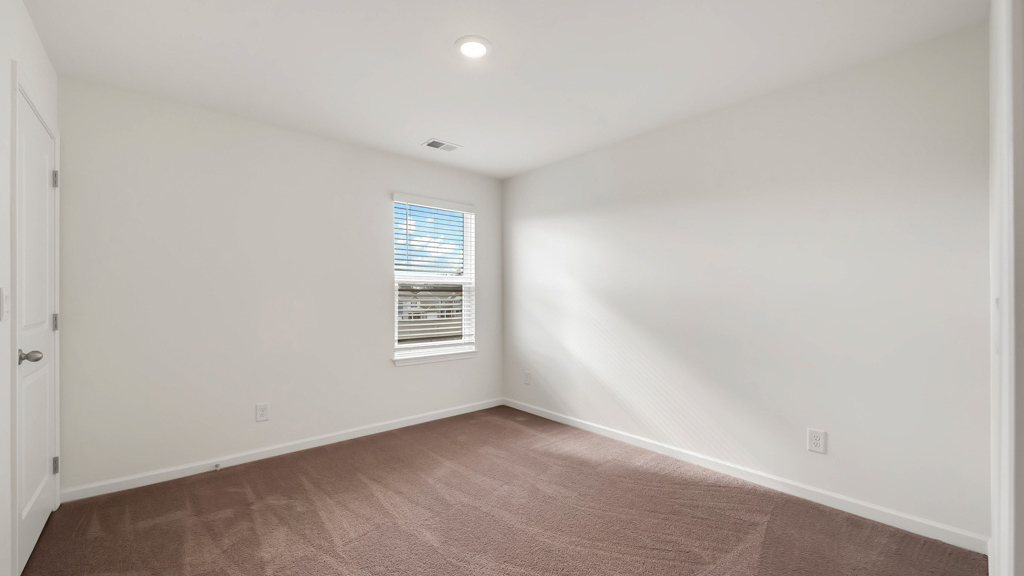 Bedroom with ample natural light and plush carpet floors
