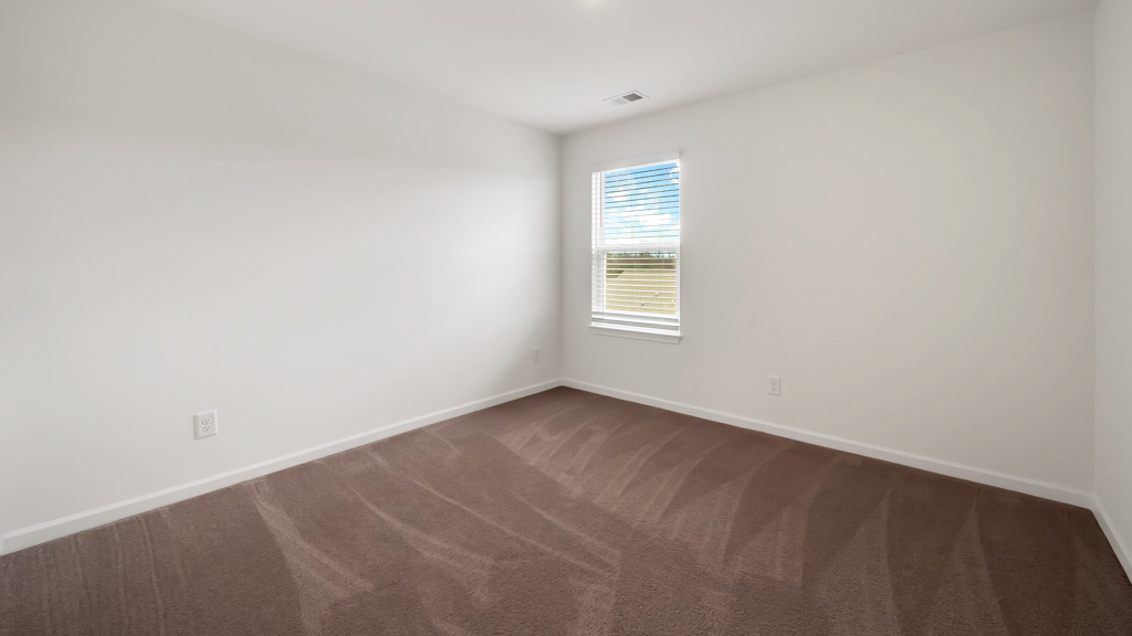 Bedroom with ample natural light and plush carpet floors