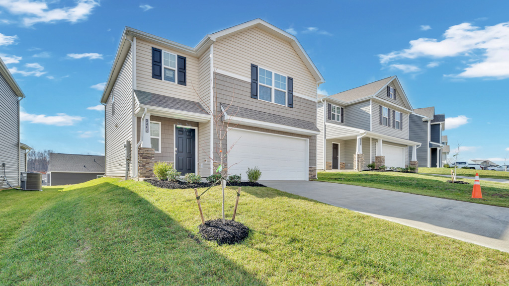Front exterior of two story home with vinyl, shake, and stone
