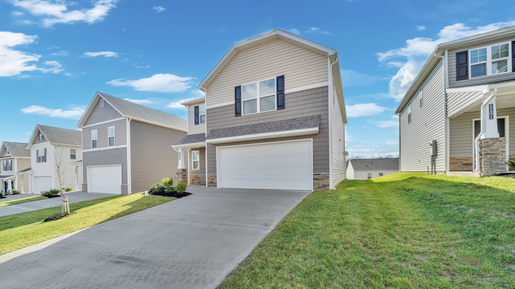 Front exterior of two story home with vinyl, shake, and stone