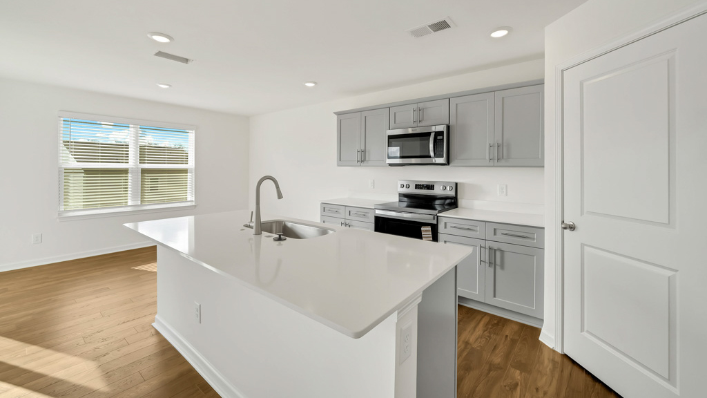 Kitchen with quartz counterops, stainless steel appliances, and shaker style cabinets