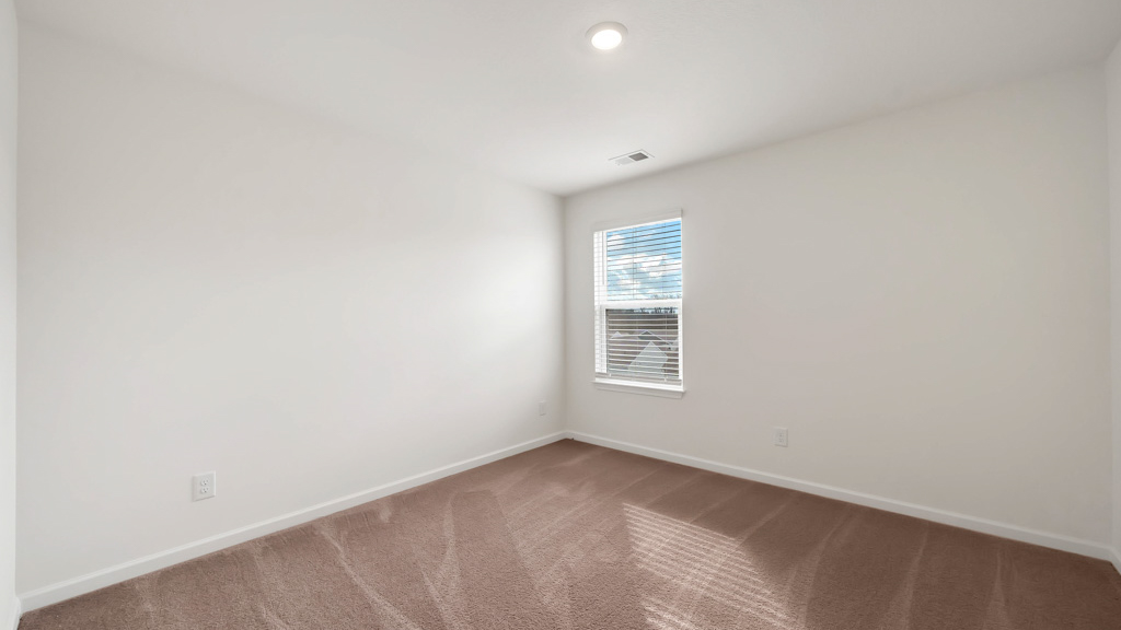 Bedroom with ample natural light and plush carpet floors