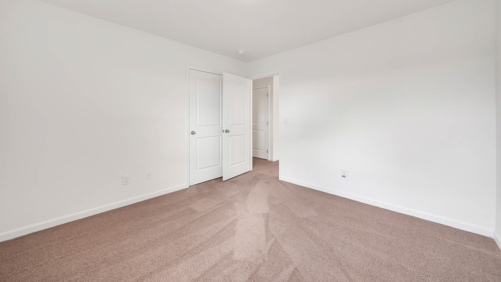 Bedroom with ample natural light and plush carpet floors