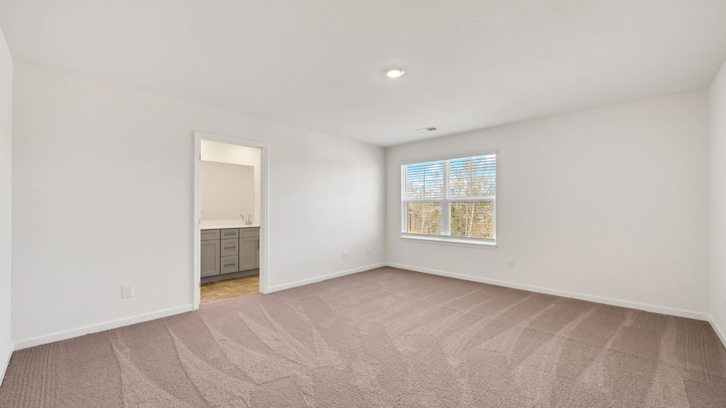Bedroom with ample natural light and plush carpet floors