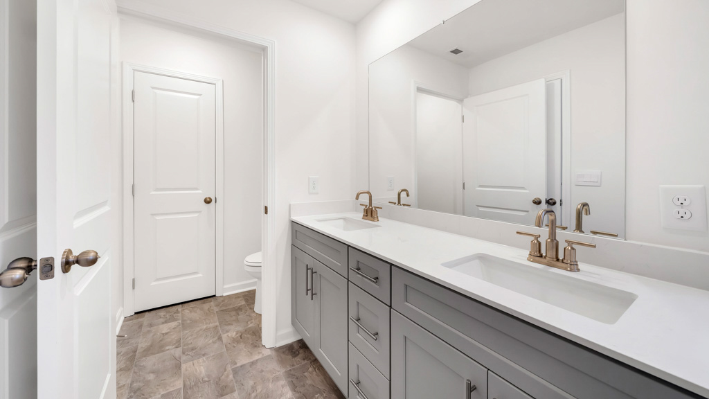 primary bathroom with double vanity and walk-in shower
