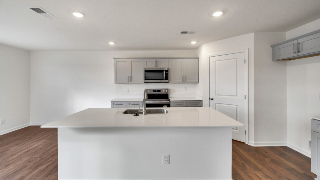 Open concept kitchen with quartz counterops, stainless steel appliances, and shaker style cabinetsOpen concept kitchen with quartz counterops, stainless steel appliances, and shaker style cabinets