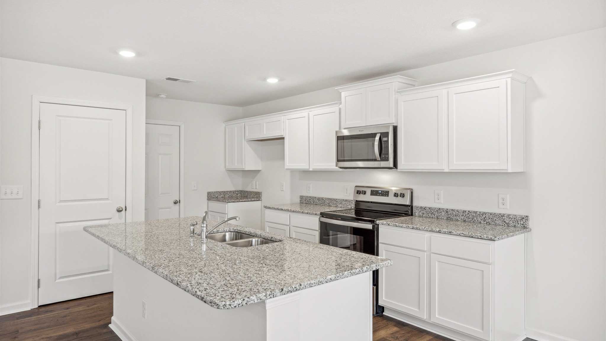 Kitchen with appliances and granite countertops.