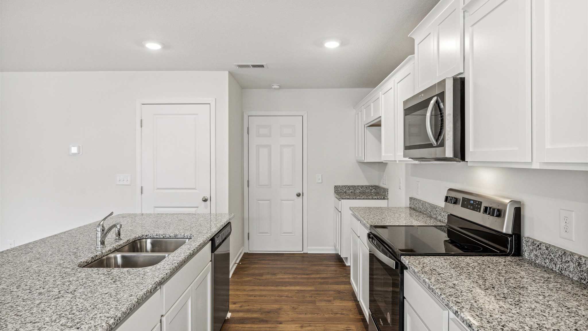 Kitchen with appliances and granite countertops.