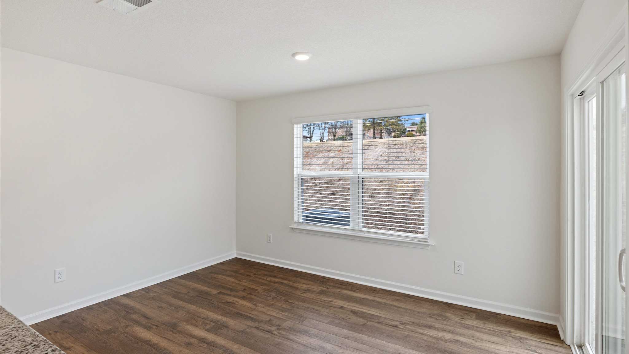 Living area with hard flooring and windows.