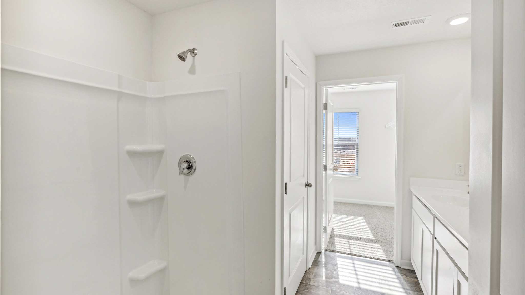 Shower bathroom door opens into bedroom.