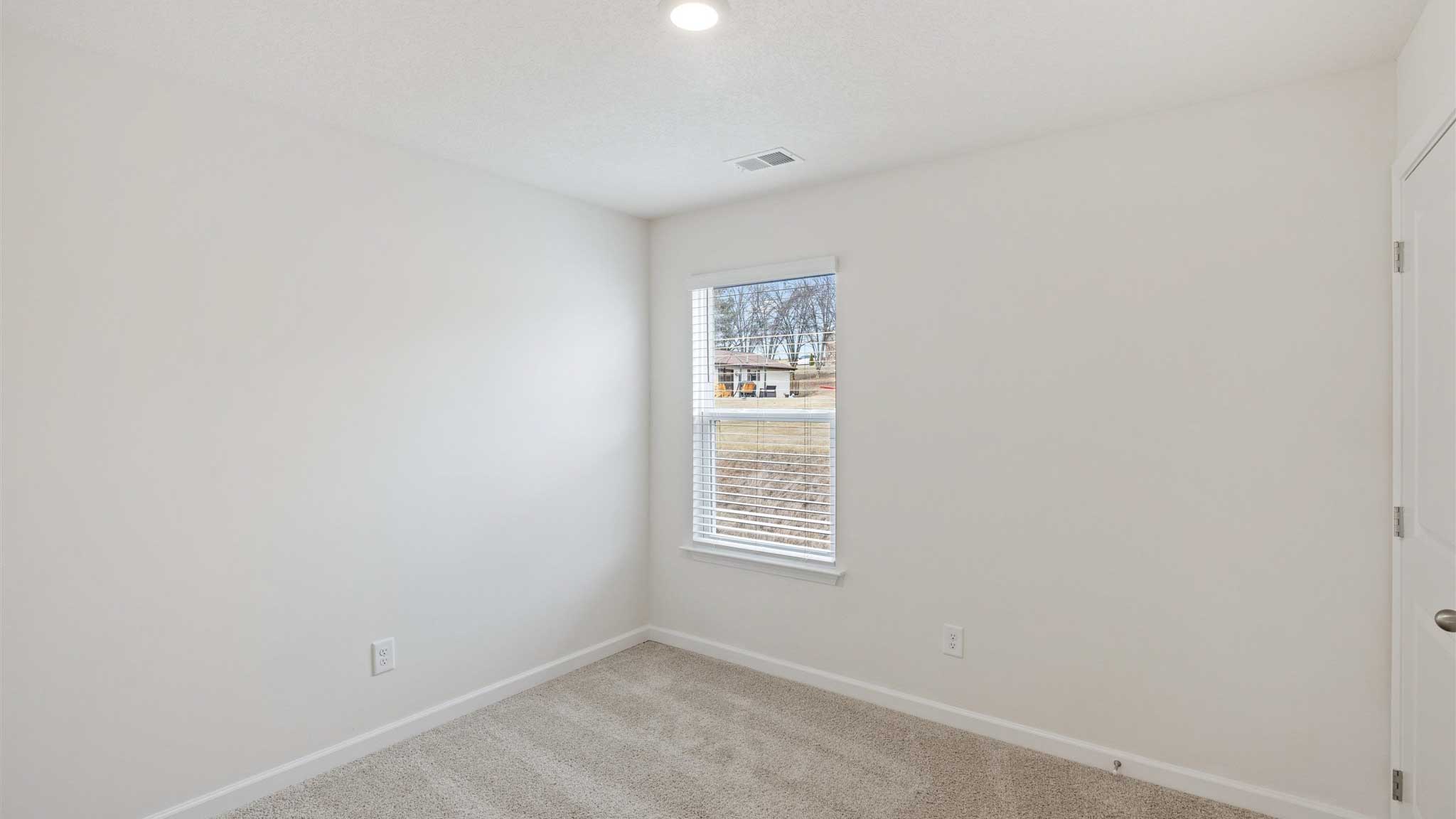 Bedroom with white waslla nd window.