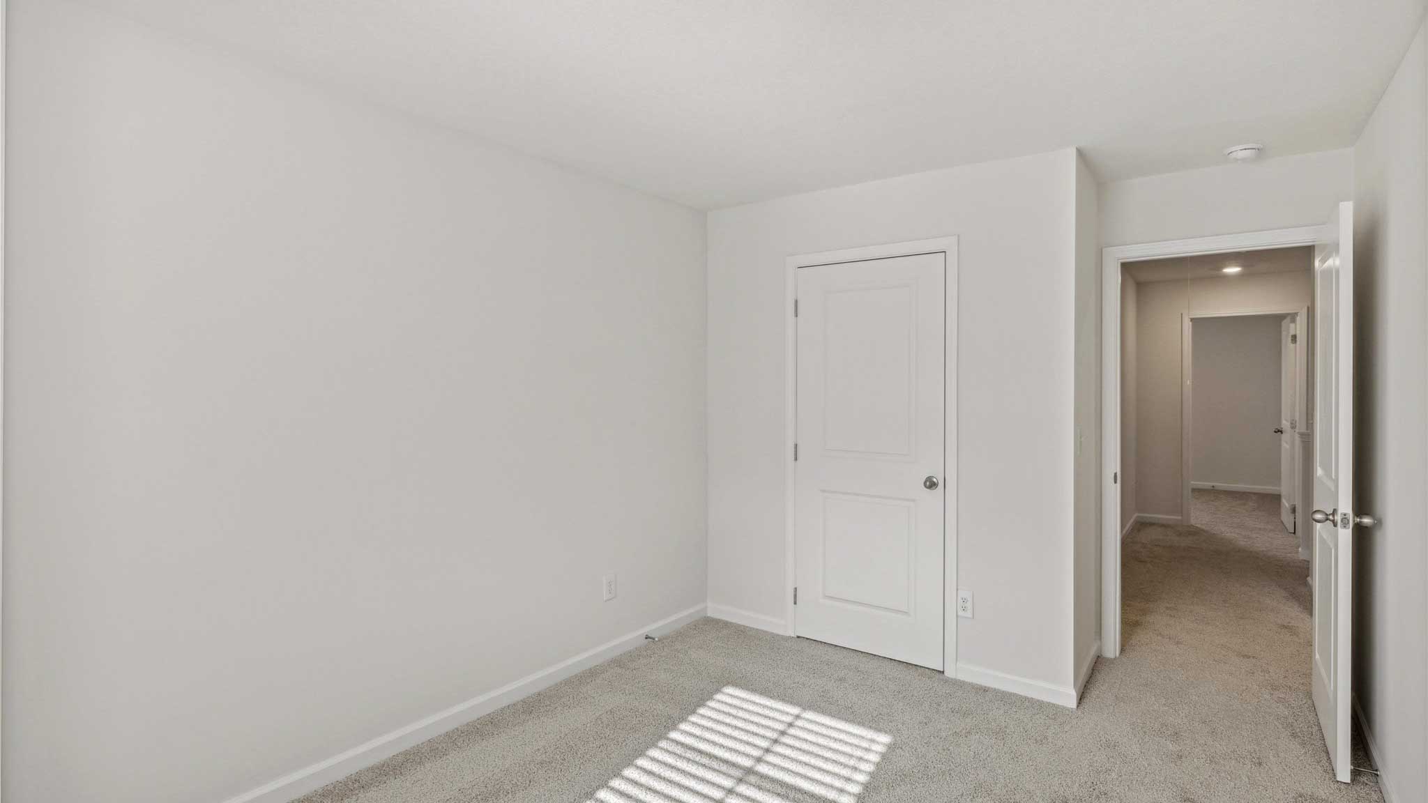 Bedroom with white walls and open closet.