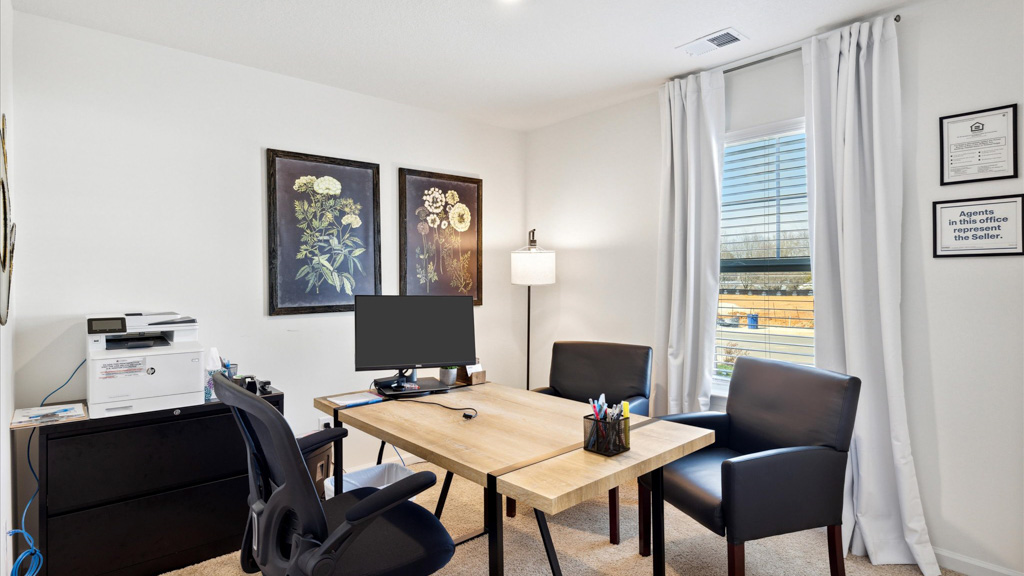 Desk with art on walls and monitor.