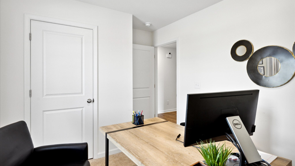 Desk with art on walls and monitor.