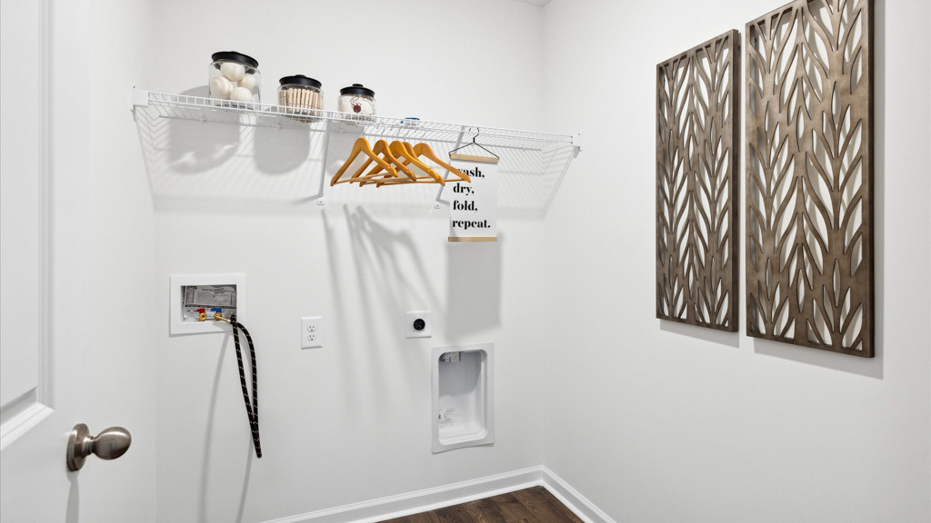 The laundry room has shelving and room for washer and dryer.