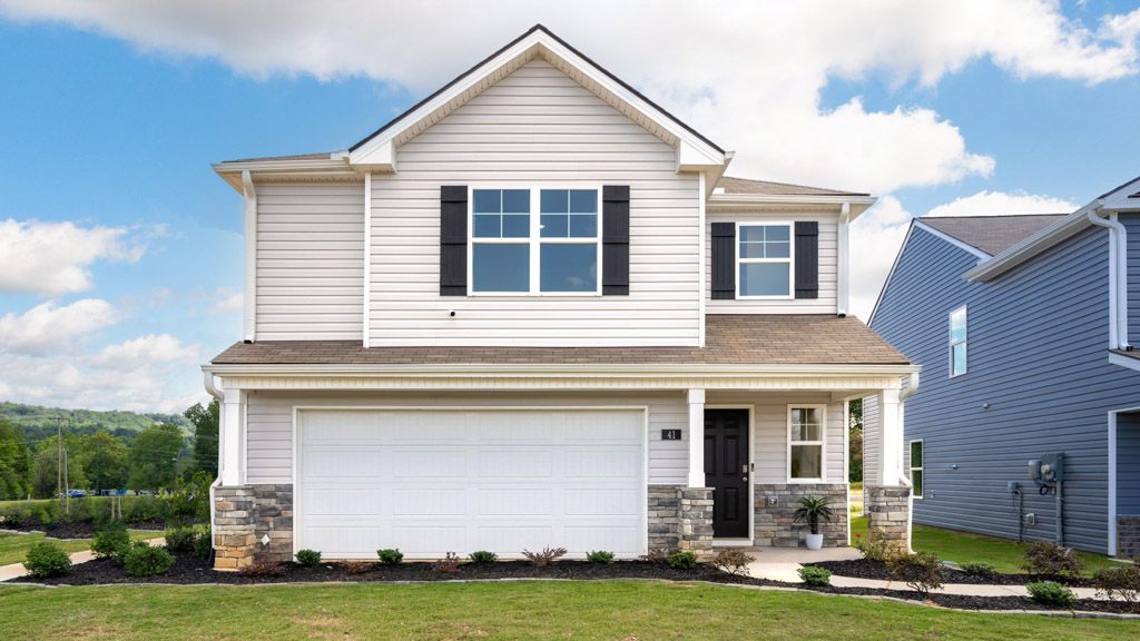 Two story home with a covered door garage and dark shutters.