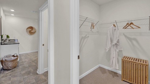 Primary closet off bathroom with shelving