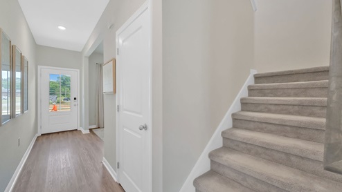 The carpeted stairs go up to the second story.