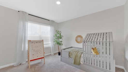 This bedroom has white walls and furniture for a playroom.