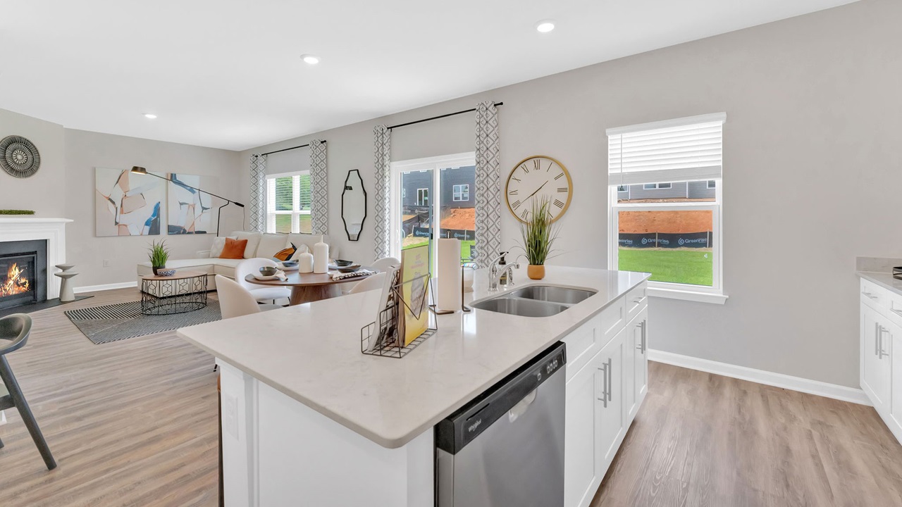 Modern kitchen with white cabinetry, granite countertops, and stainless-steel appliances in a D.R. Horton home