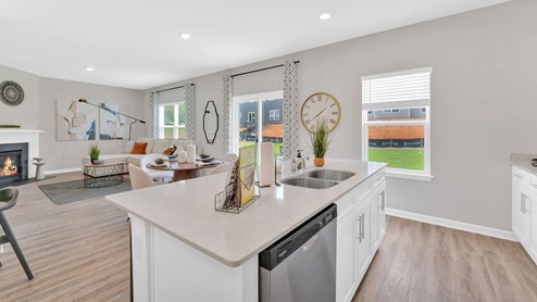 A modern kitchen featuring white cabinets and elegant hardwood floors, creating a bright and inviting atmosphere.