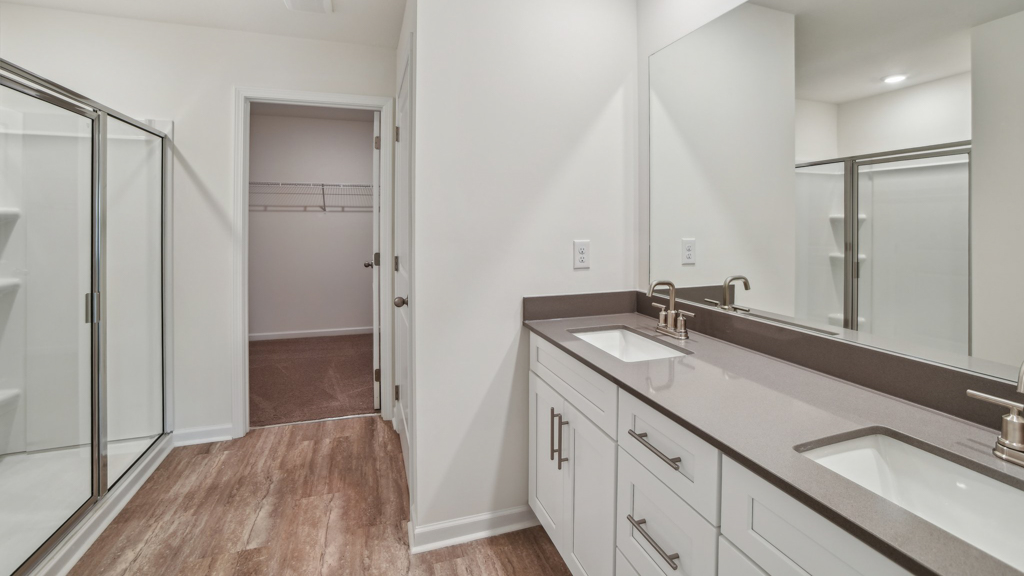 Bathroom with double vanity sinks and a walk in shower.