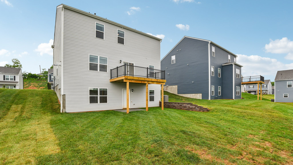 Rear exterior of home with view of deck.