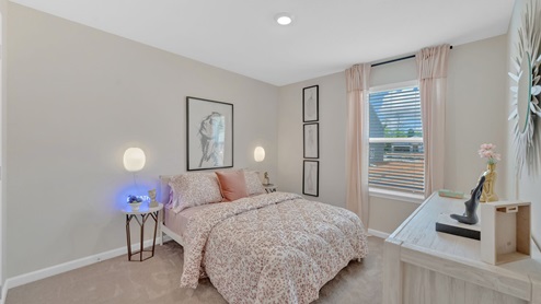 The secondary bedroom has a bed, end tables, dresser and end table.
