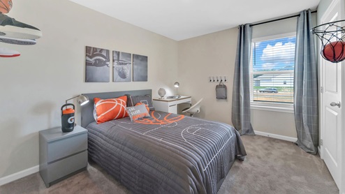 A bedroom with windows allowing natural light and cozy carpeting, perfect for a fresh start or new ideas.