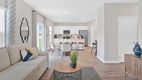The living room has hardwood floors, white walls and furnished comfortably.