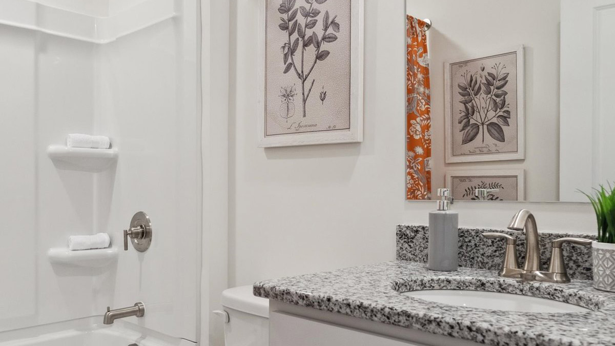 Full bathroom with tub and shower surround combo, vanity, mirror, storage options at Saint Andrews Garth