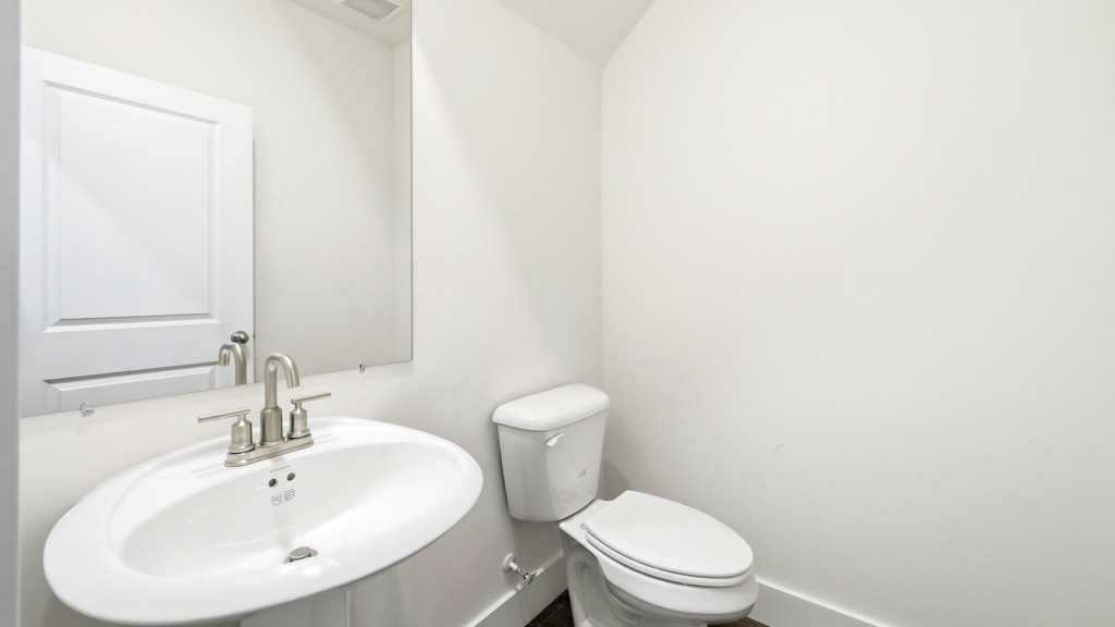 powder room half bathroom with pedestal sink and large mirror