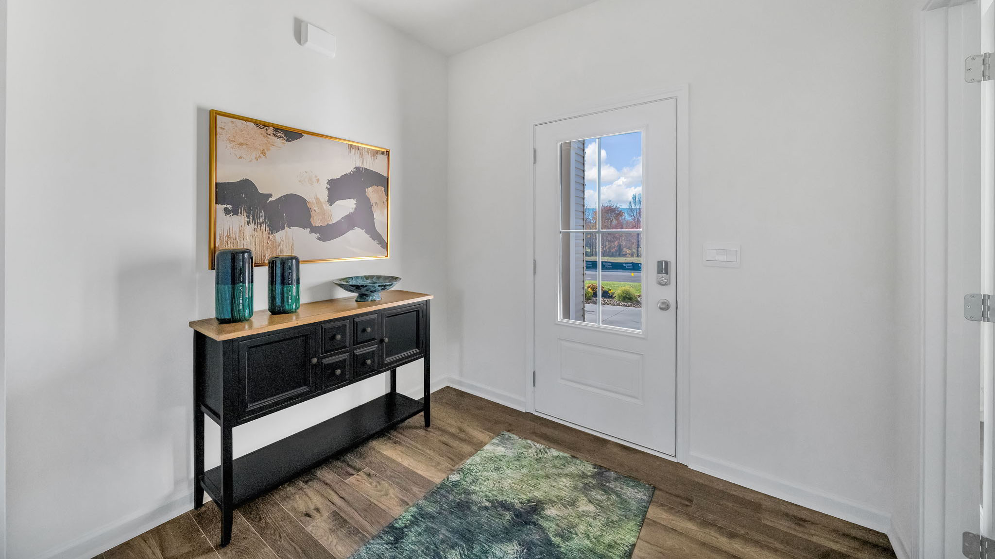 The entryway has a small piece of furniture next to the door