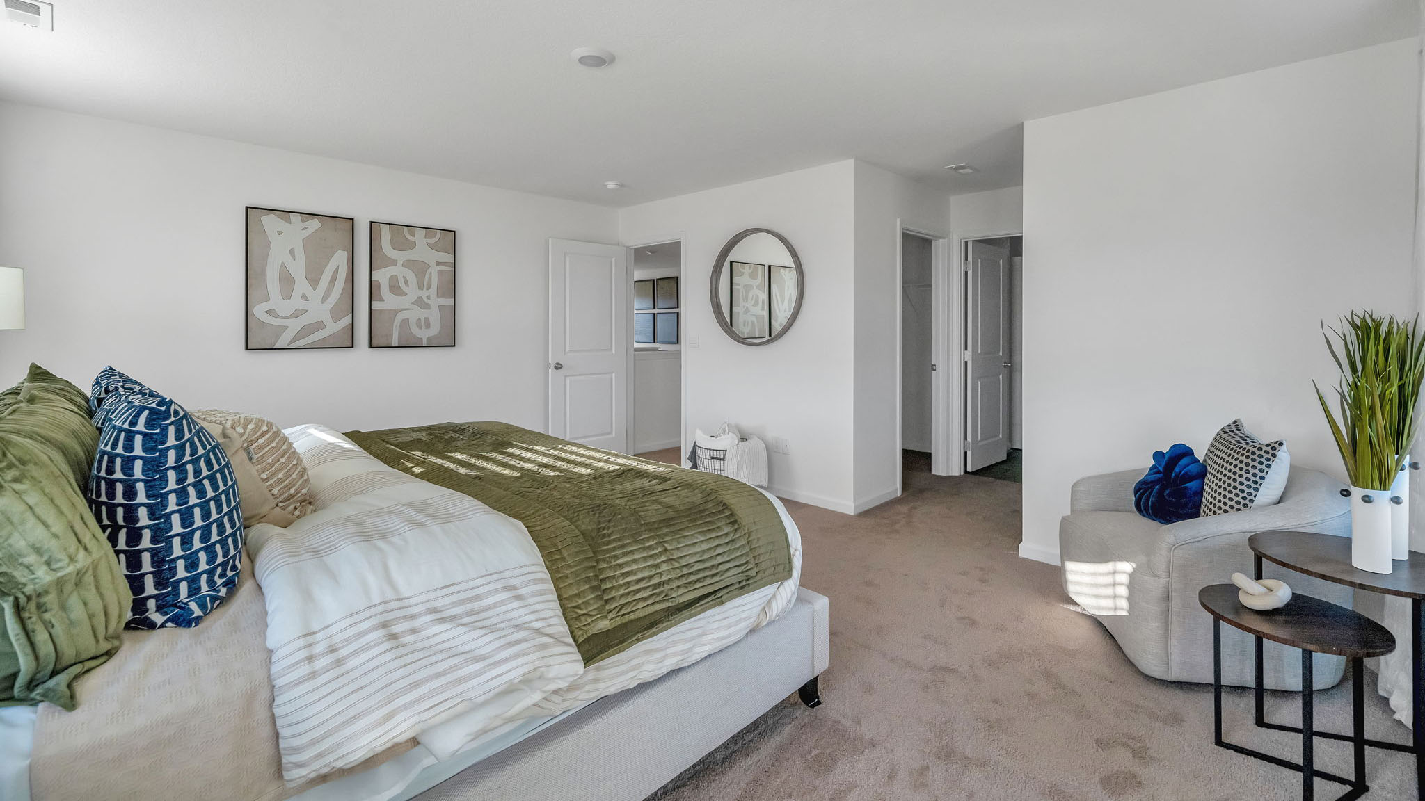 There is a mirror on the wall of the master bedroom and seating