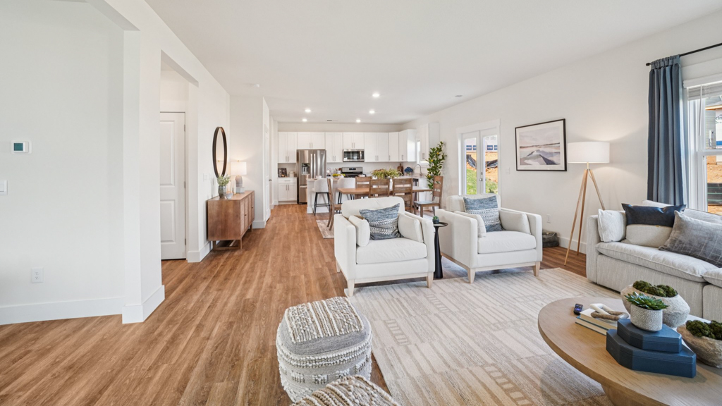 Living room looking to kitchen, dining, outdoor areas in this new home features natural light, with fresh open concept flow