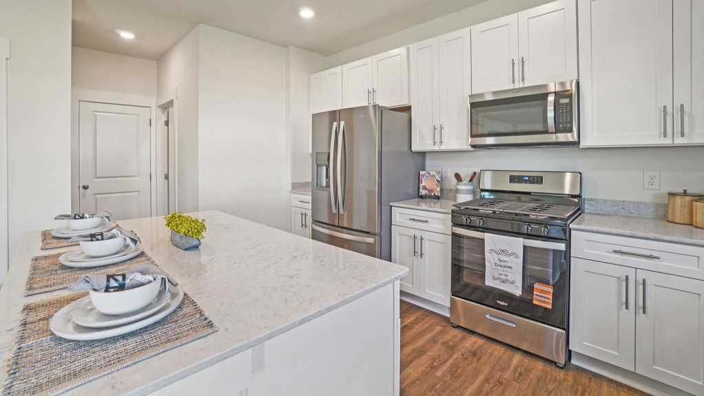 Functional kitchen island adds a sink, multi-prep zones, cabintes and a pantry, new appliance suite, and outside access