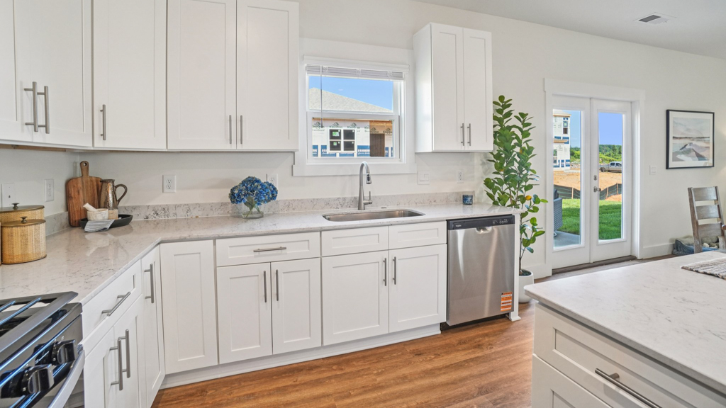 Kitchen island in D.R. Horton layout connects dining, main living areas, and outside with efficient flow and modern designs