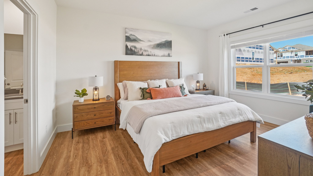 Primary bedroom features ample space, double windows, soft carpet, a stylish walk-in closet, and a private ensuite bath